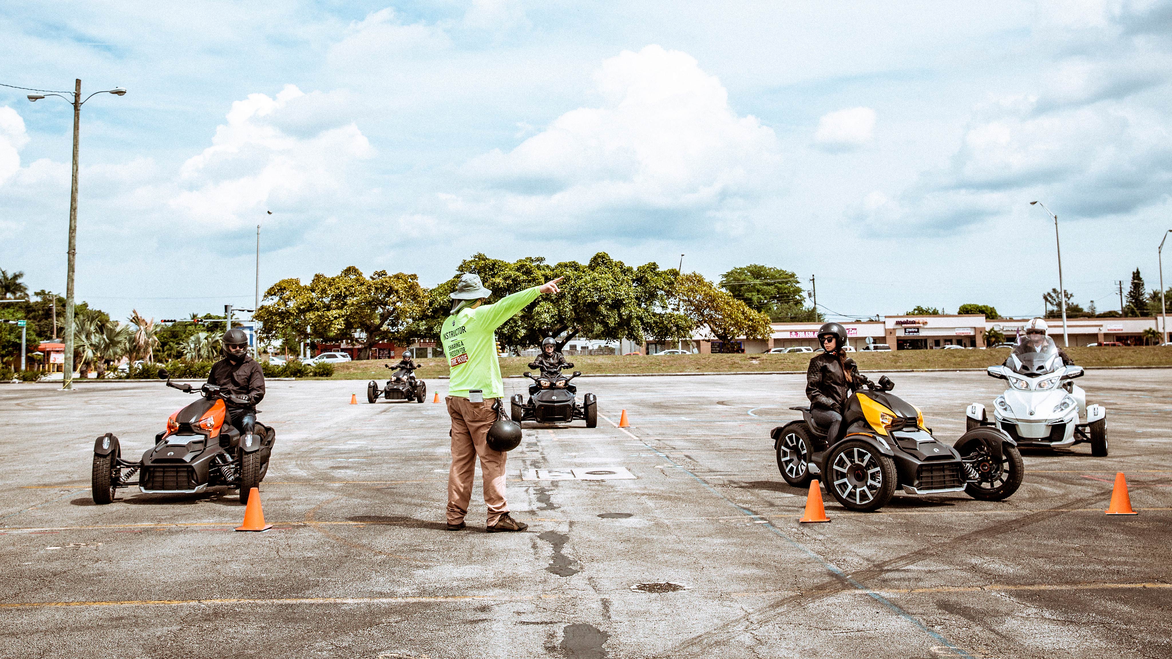 Couple riding on Can-Am Ryker vehicle with yellow shock panels